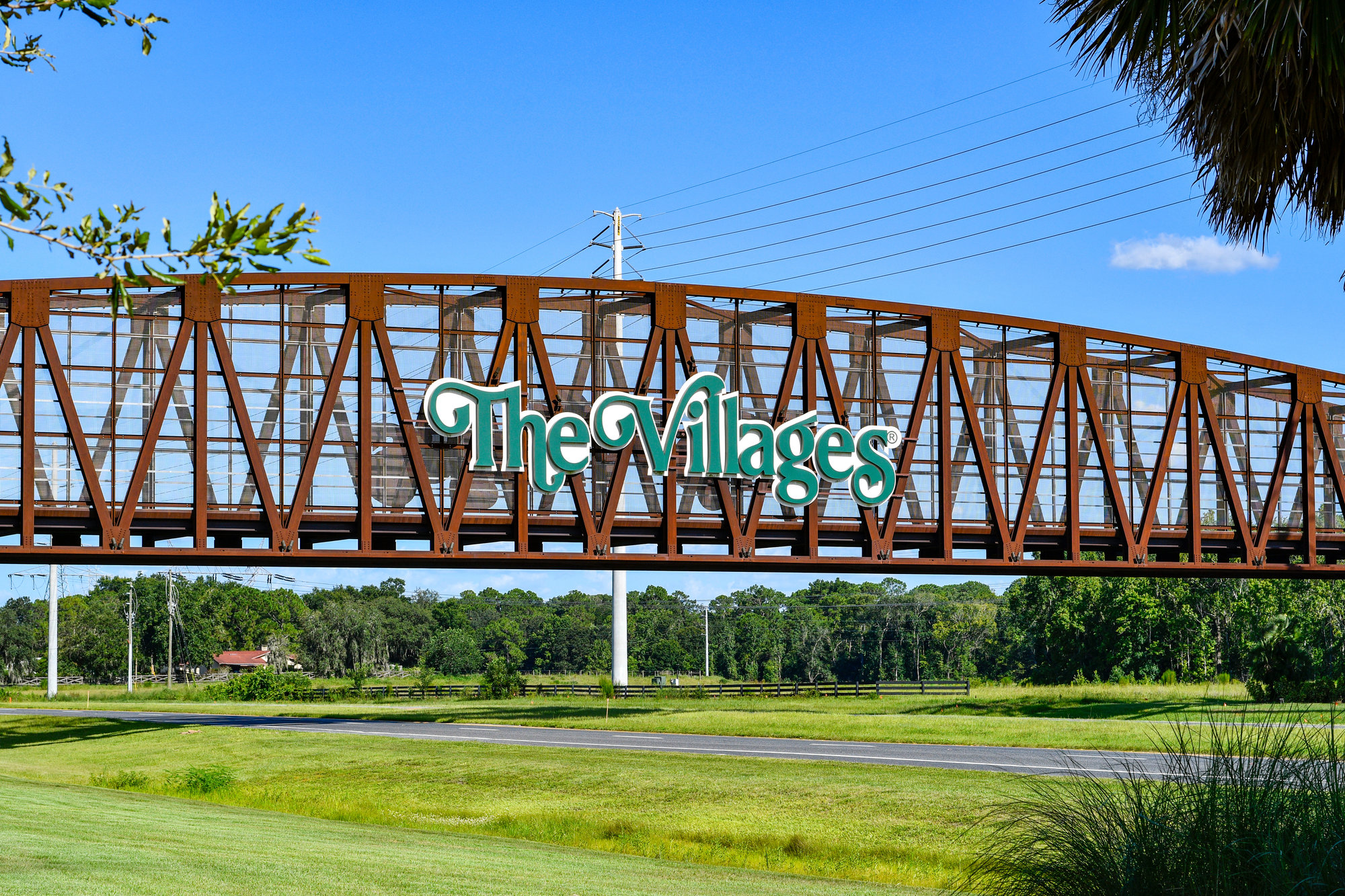 the villages sign on a metal bridge